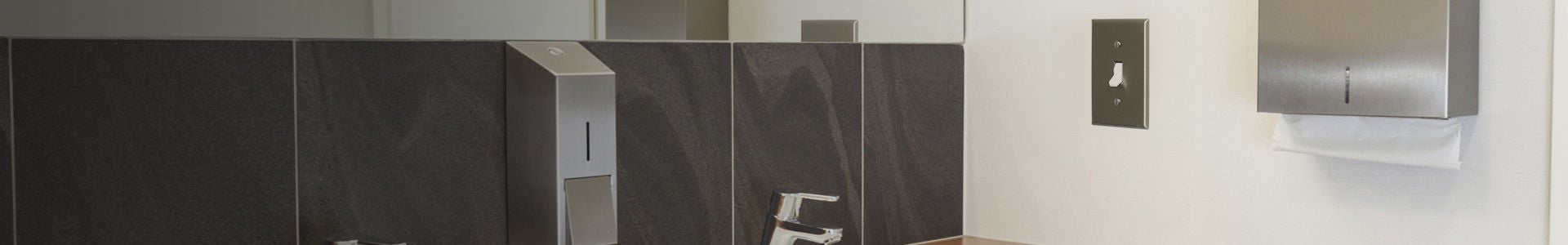 Interruptor comercial con placa de pared de acero inoxidable en un baño público